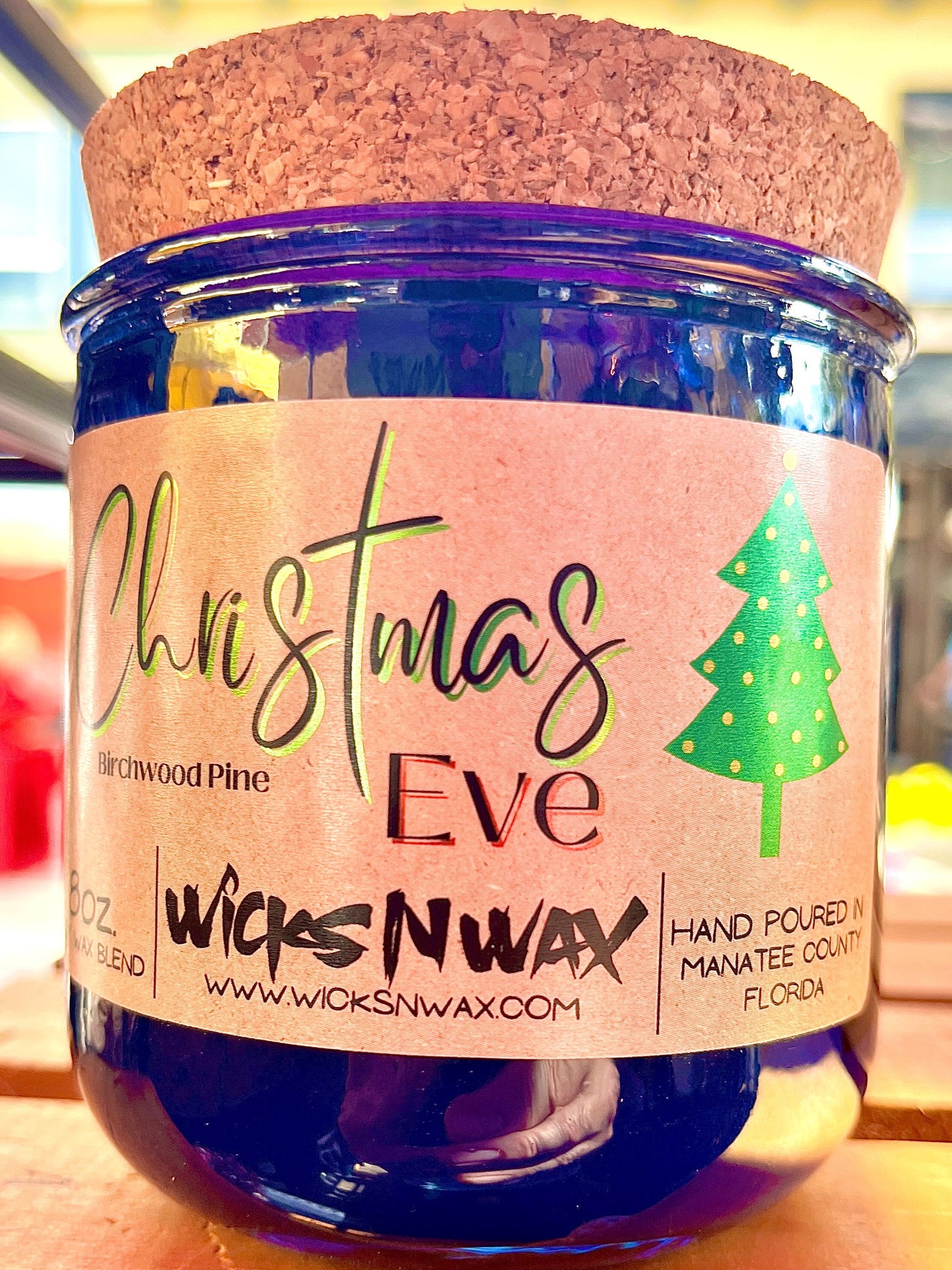 Blue glass candle with cork lid, “Christmas Eve” label and pine tree graphic