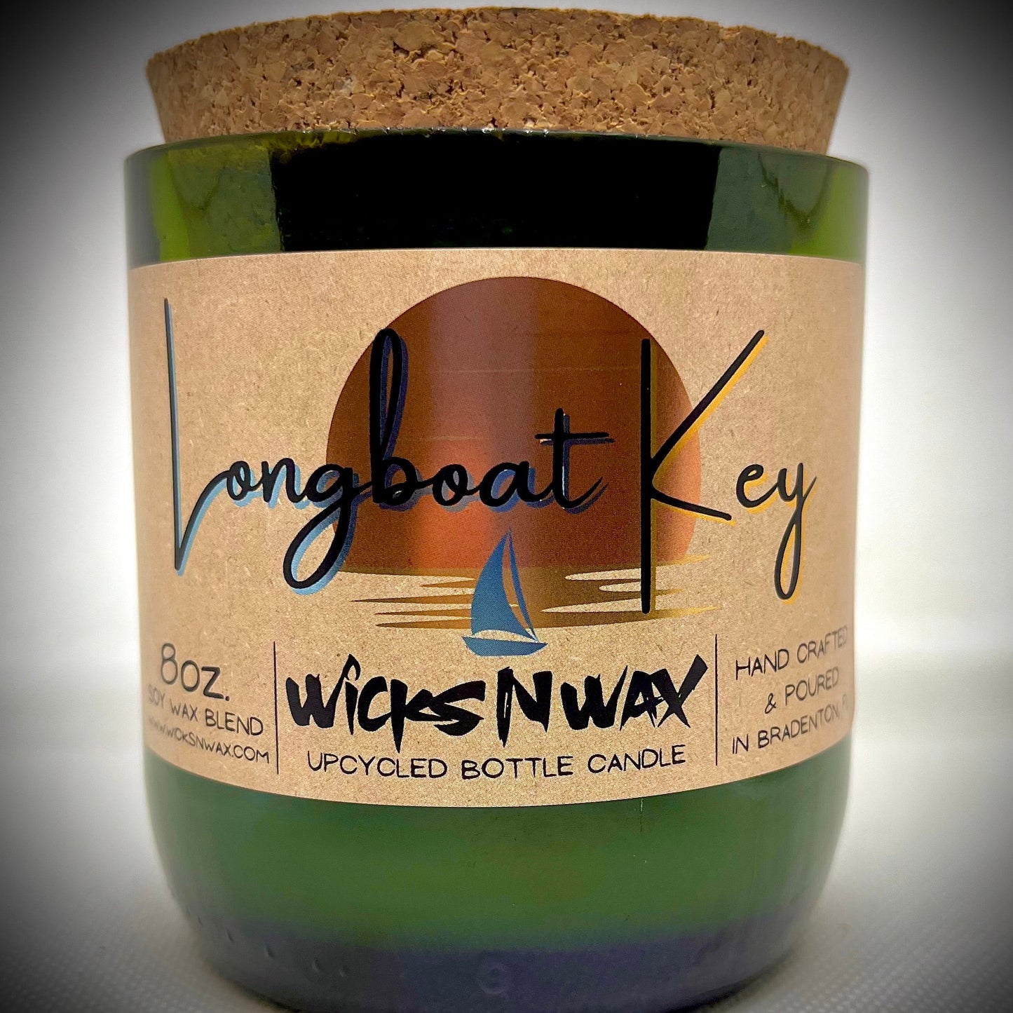 Champagne bottle candle in green glass jar with Longboat Key label and WicksNWax branding