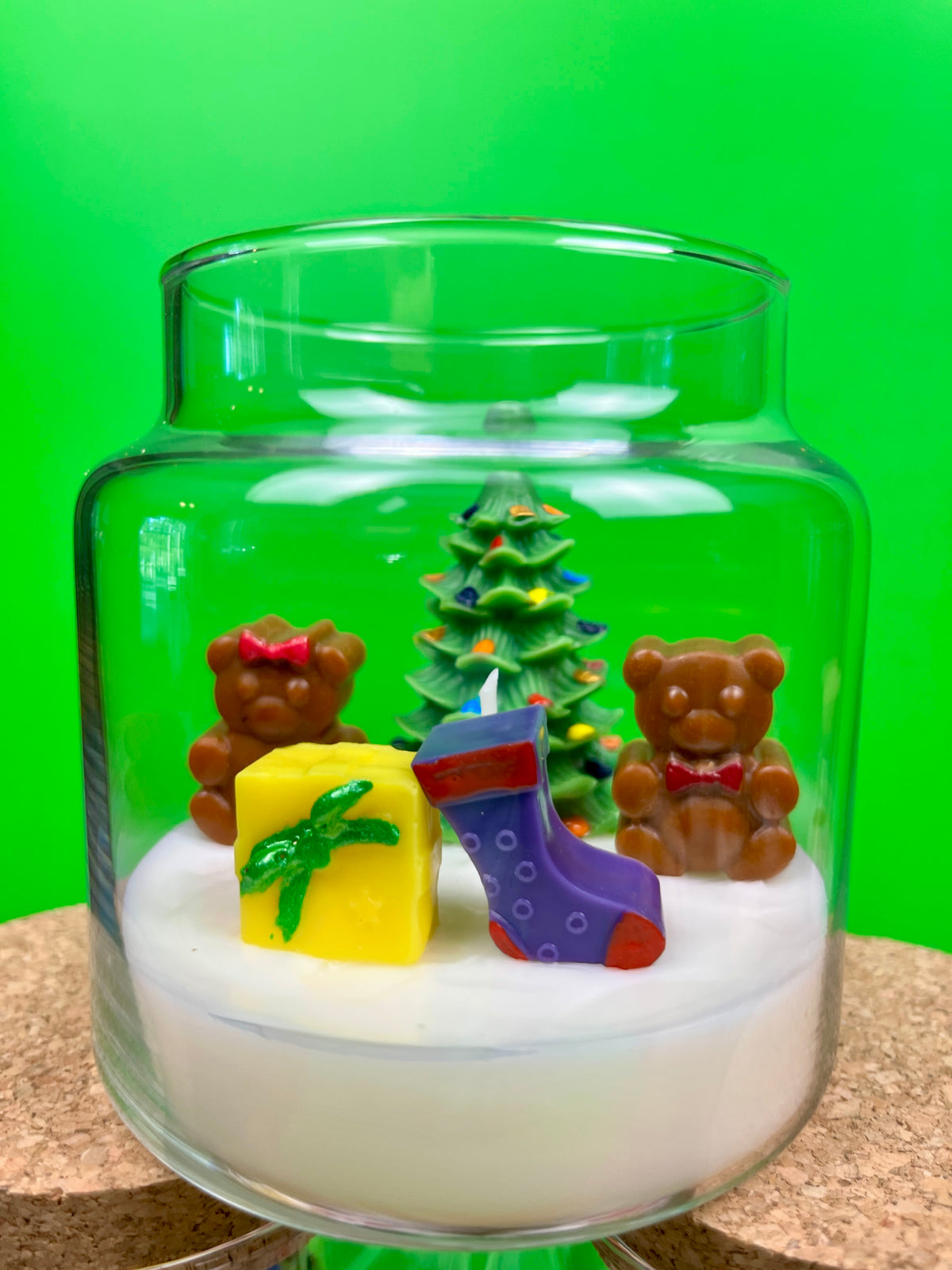 Christmas candle in a glass jar with a tree, teddy bears, gift, and purple stocking embed