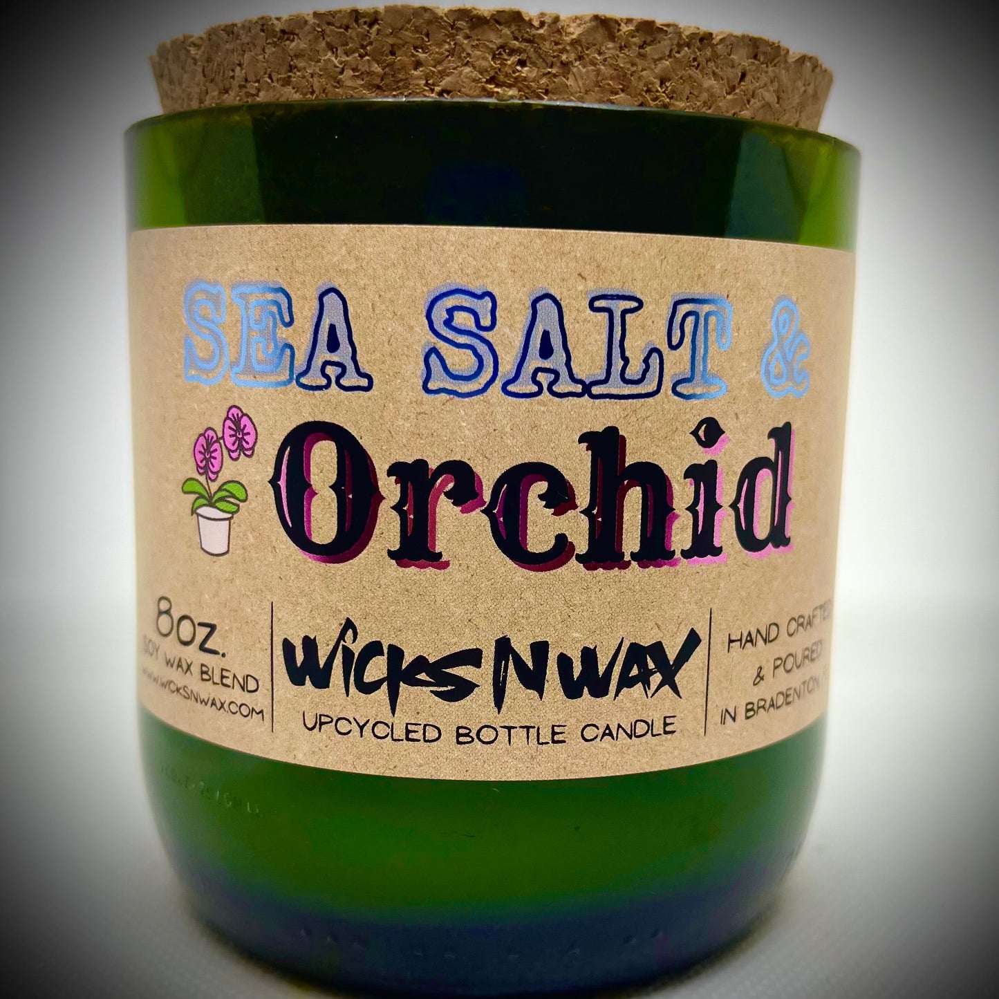 Champagne bottle candle in green glass with Sea Salt & Orchid label, WicksNWax logo
