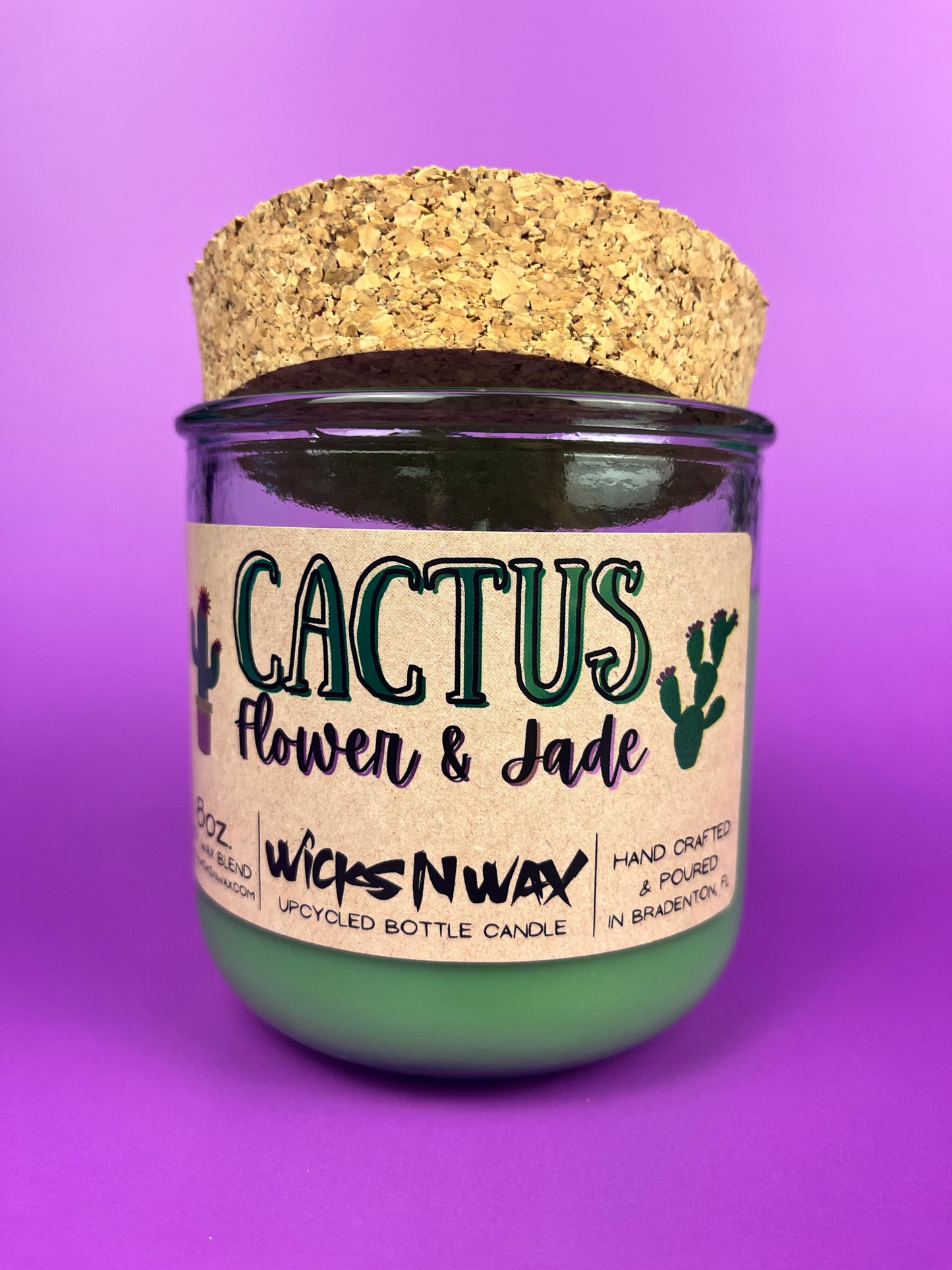 Recycled glass candle jar with printed label, green wax base, and tan cork top
