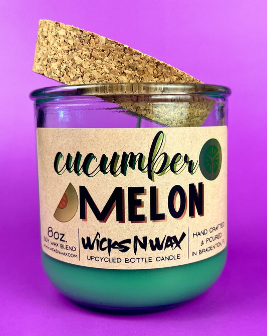 Recycled glass candle with green wax and front label, cork lid slightly angled