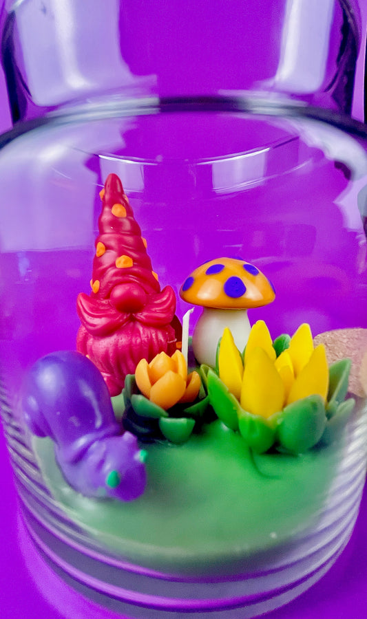 Garden gnome art candle in clear glass jar with green wax and flower figurines