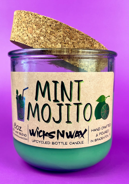 Recycled glass candle with mint-green wax, cork lid, label and fragrance icons visible