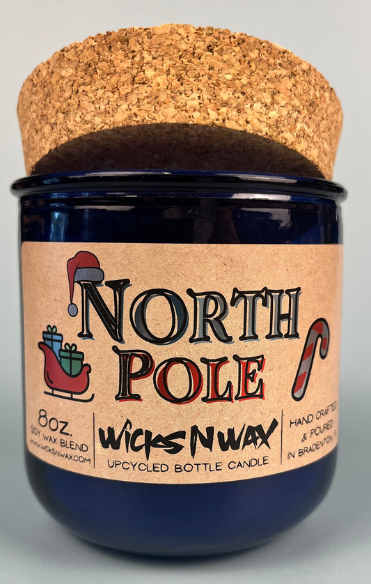 Blue glass candle jar on cork base with North Pole label and WicksNWax logo.