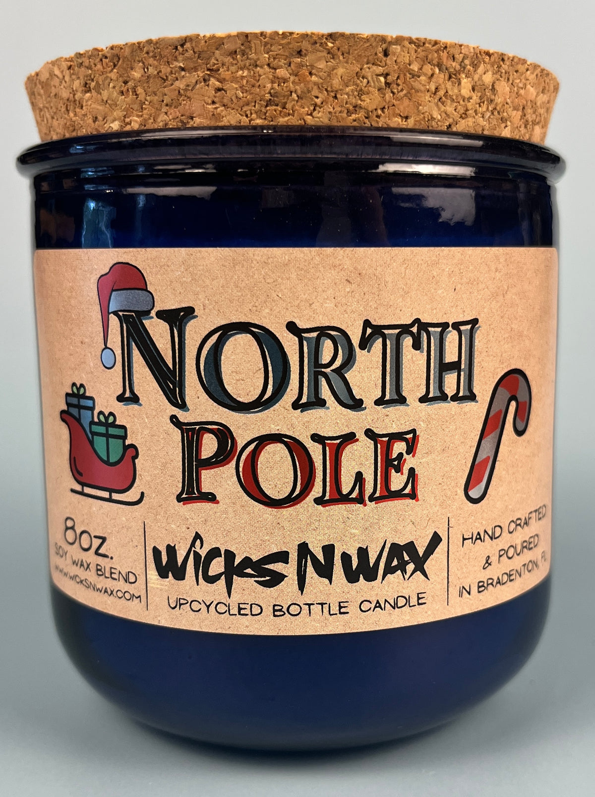 Blue glass candle jar with cork base and North Pole label, hand crafted text.