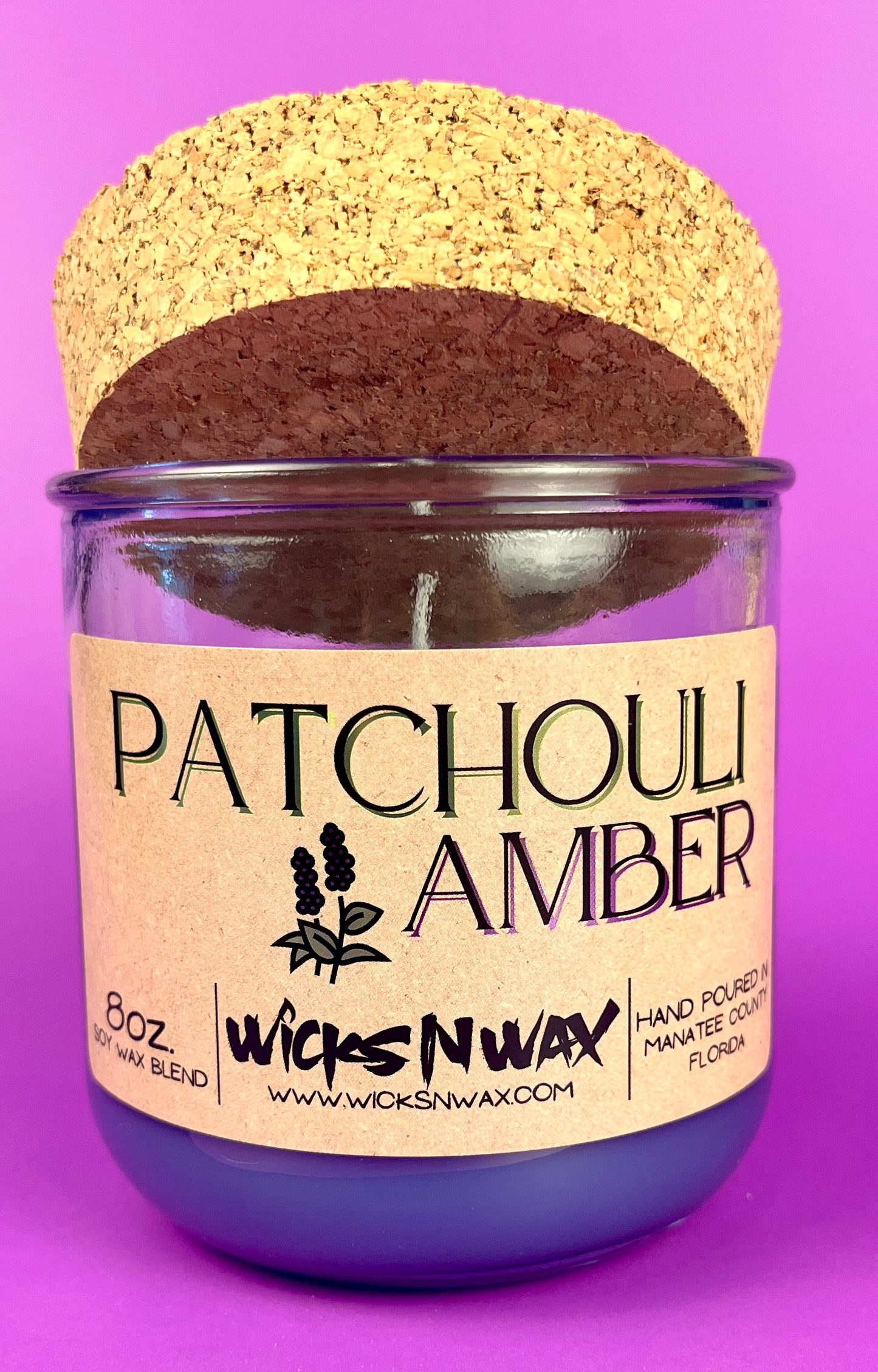 Recycled glass candle in clear jar with purple wax and cork lid, front label.