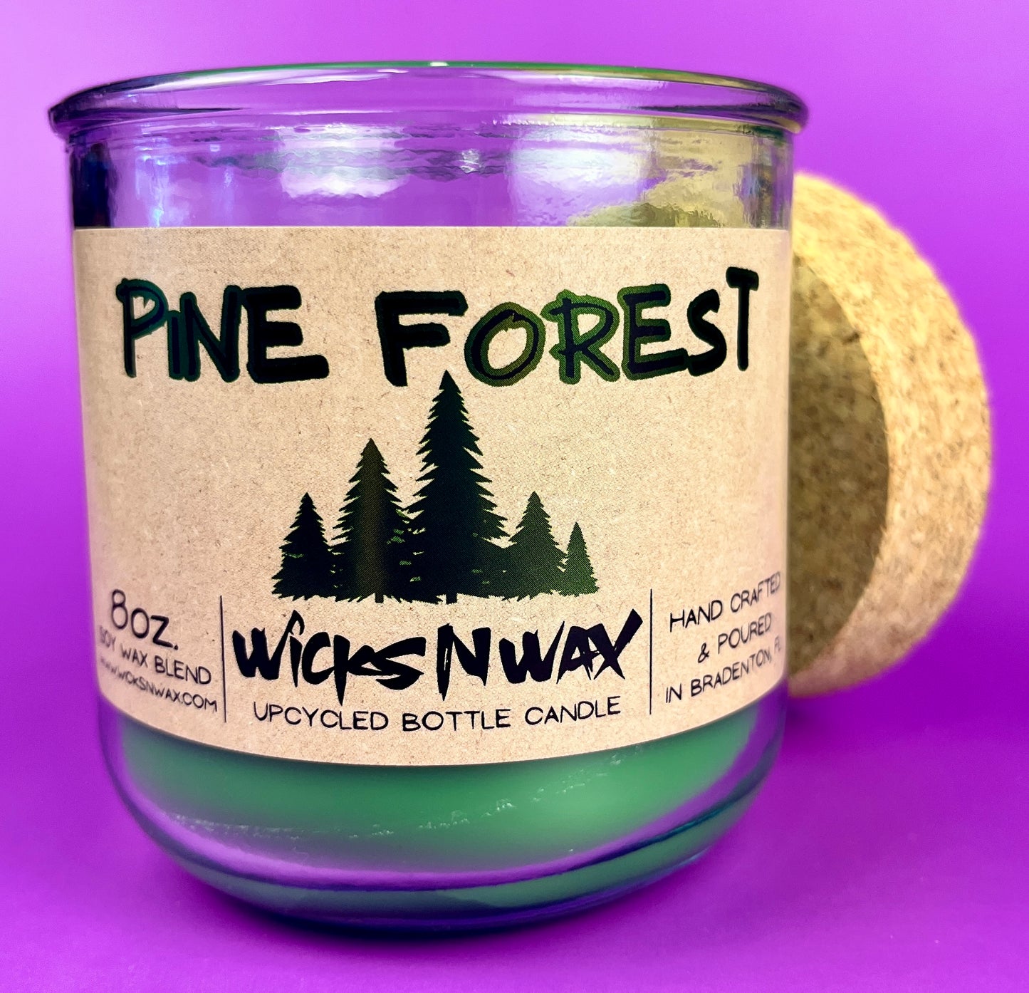 Pine Forest recycled glass candle with green wax in a purple glass jar, cork lid