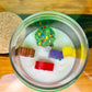Christmas art candle viewed from above, showing a decorated tree and colorful wax figures