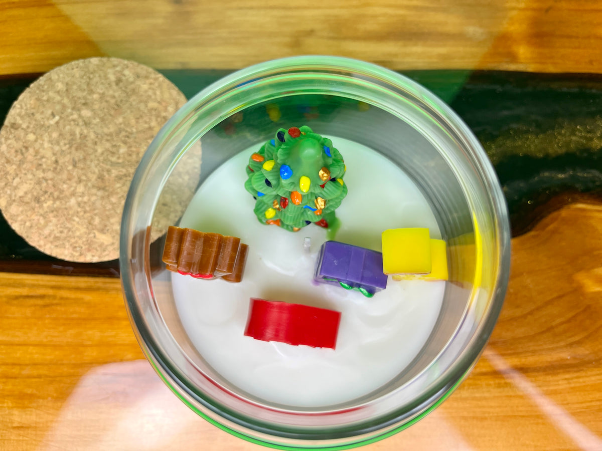 Christmas art candle viewed from above, showing a decorated tree and colorful wax figures