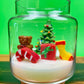 Christmas art candle in a glass jar with a molded tree, bear, candy cane and stocking