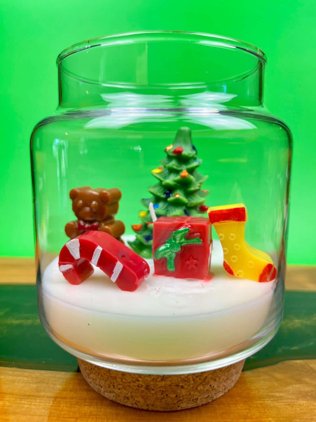 Christmas art candle in a glass jar with a molded tree, bear, candy cane and stocking