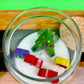 Christmas art candle viewed from above, with a molded tree and colorful wax shapes