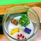 Christmas art candle seen from above, with a tree, candy cane, stocking and gift shapes