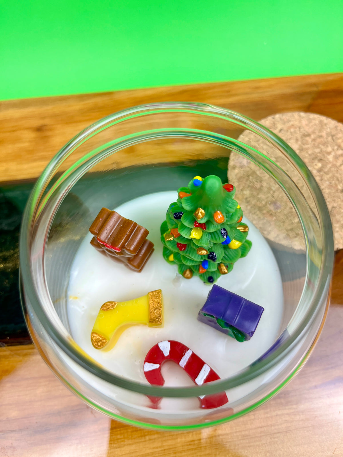 Christmas art candle seen from above, with a tree, candy cane, stocking and gift shapes