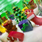 Christmas art candle in a glass jar, with white wax and colorful molded holiday decorations