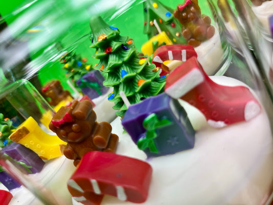 Christmas art candle in a glass jar, with white wax and colorful molded holiday decorations