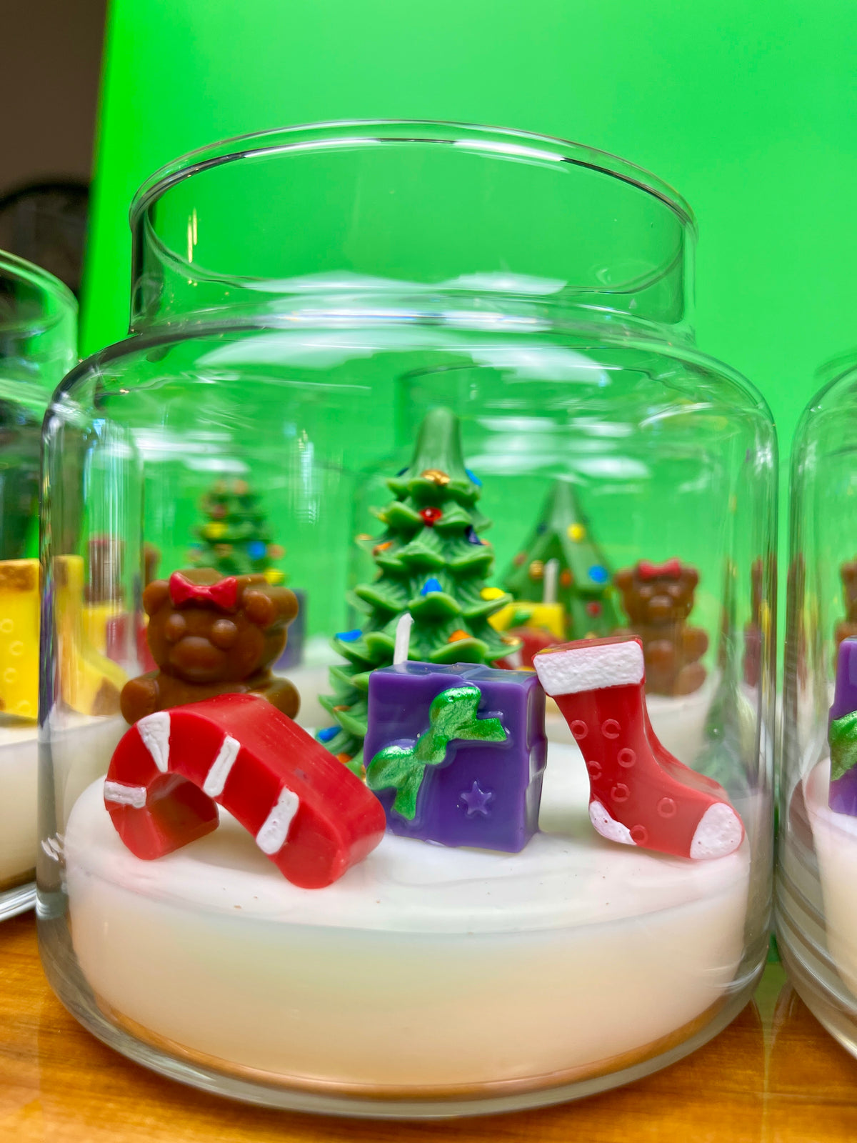 Christmas candle in a glass jar with a tree, teddy bears, gifts, and stocking embeds