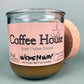 Recycled glass candle, amber wax, pink label facing forward, with cork coaster behind