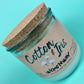 Recycled glass candle with cork lid, kraft label and “Cotton & Iris” logo, angled