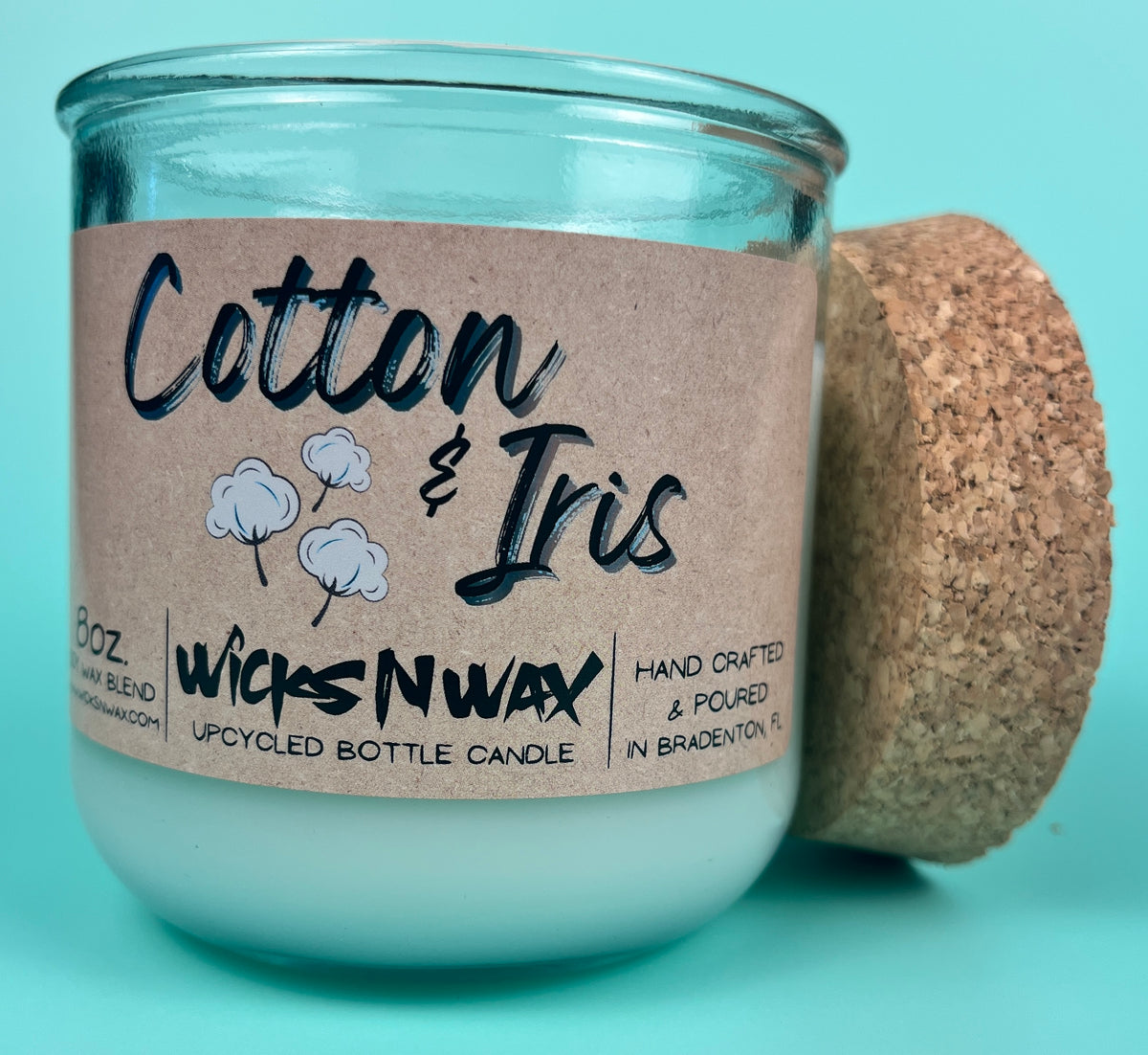 Recycled glass candle with cork lid and “Cotton & Iris” kraft label, side view