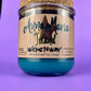 Recycled glass bottle candle with blue wax, beige label, and cork lid on top