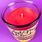 Recycled glass candle with red wax and visible wick center