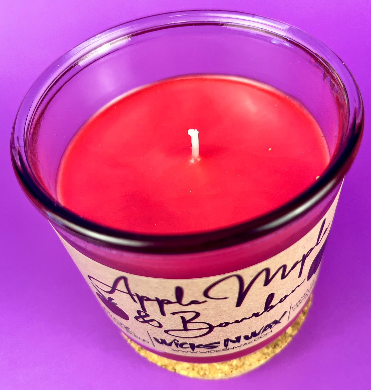 Recycled glass candle with red wax and visible wick center