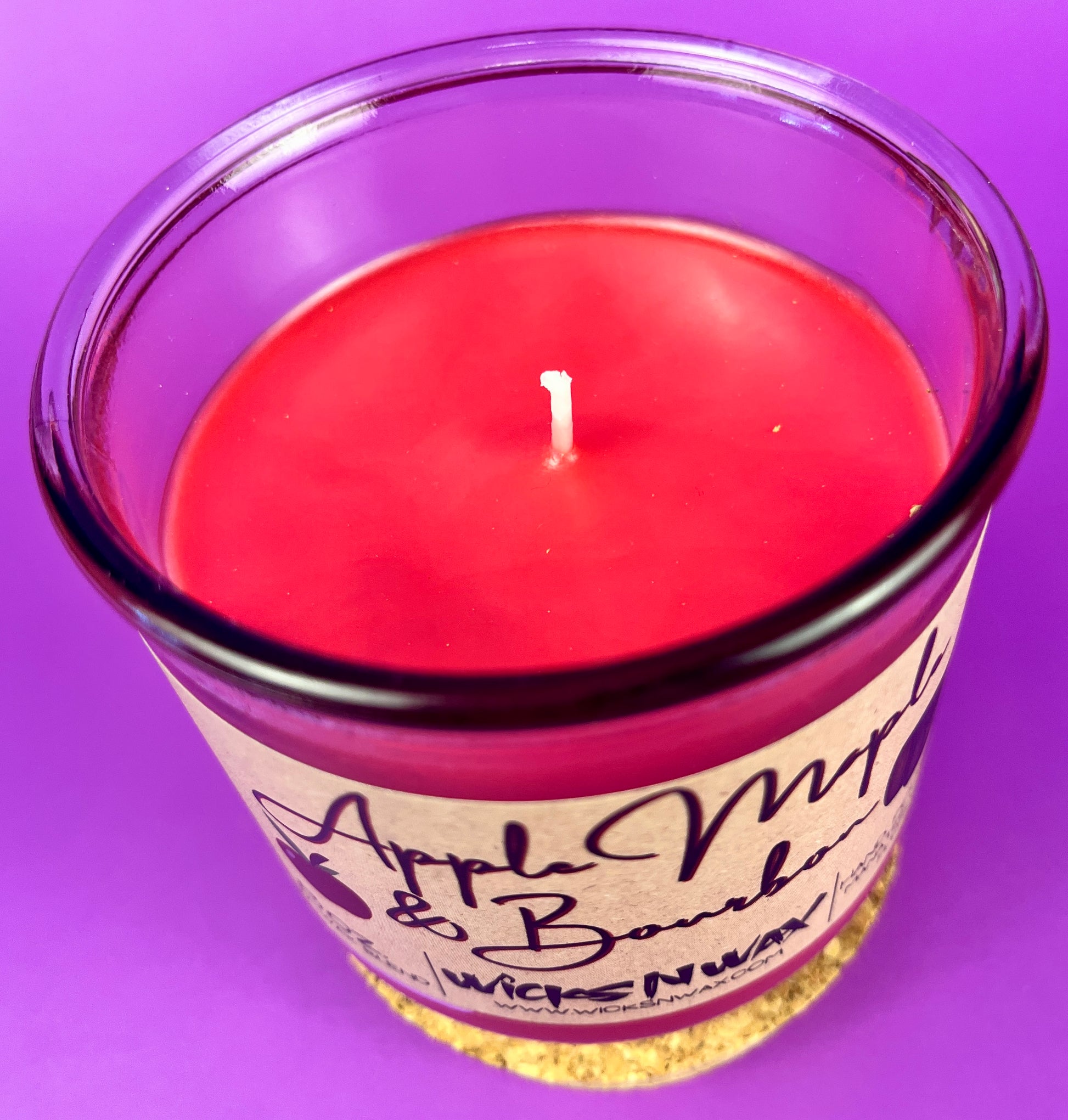 Recycled glass candle with red wax and visible wick center