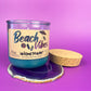 Recycled glass candle with blue wax, clear jar, cork lid and base, beach-themed label