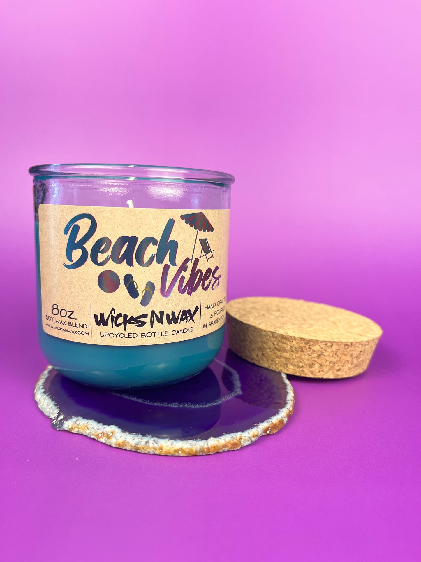 Recycled glass candle with blue wax, clear jar, cork lid and base, beach-themed label