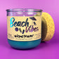 Recycled glass candle with blue wax, clear jar, cork lid on side, beach-themed label