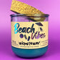 Recycled glass candle with blue wax, clear jar, cork lid piece, beach-themed label