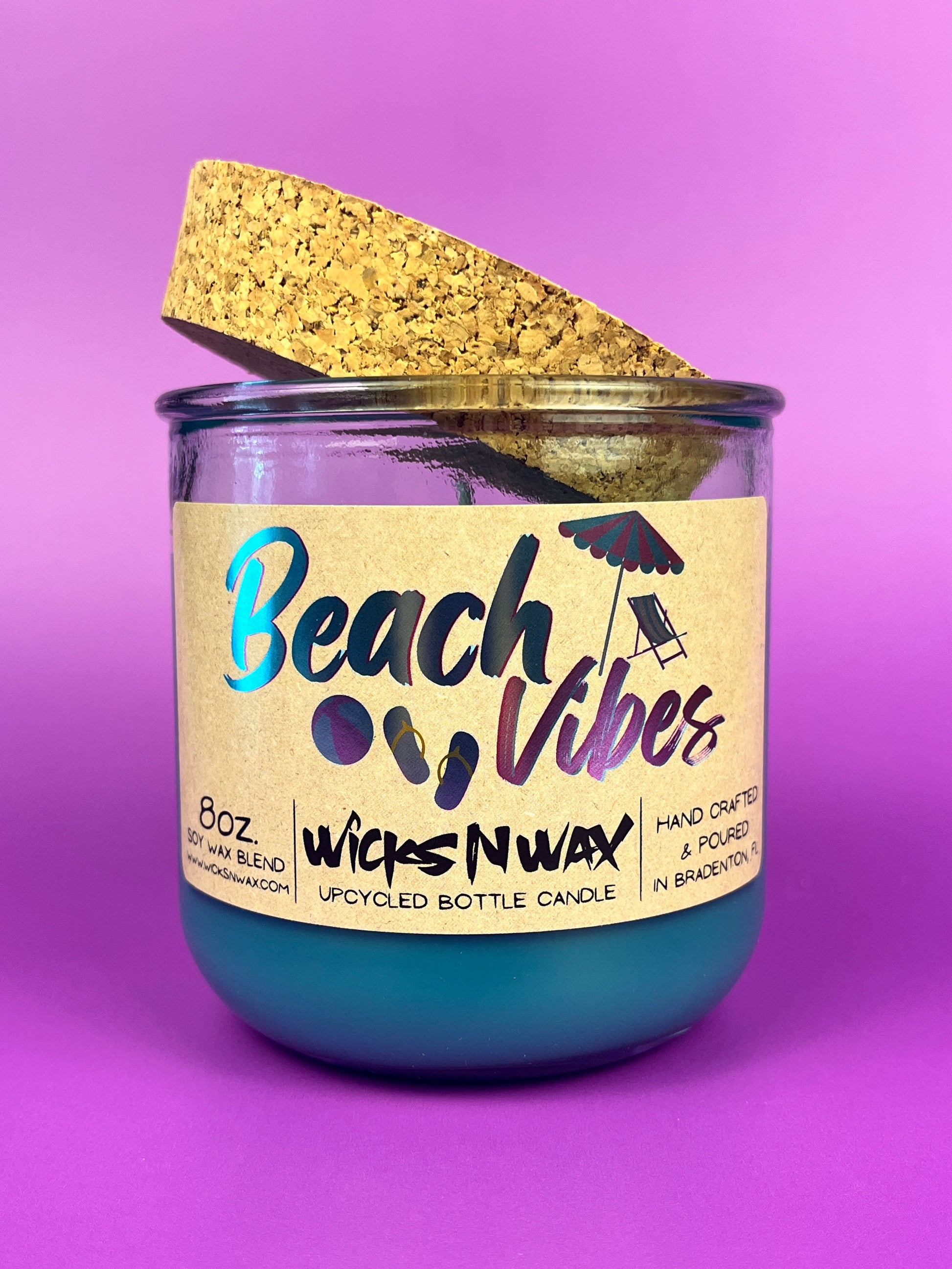 Recycled glass candle with blue wax, clear jar, cork lid piece, beach-themed label