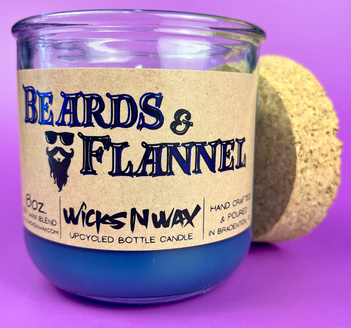 Blue recycled bottle candle with cork lid, front label "Beards & Flannel".