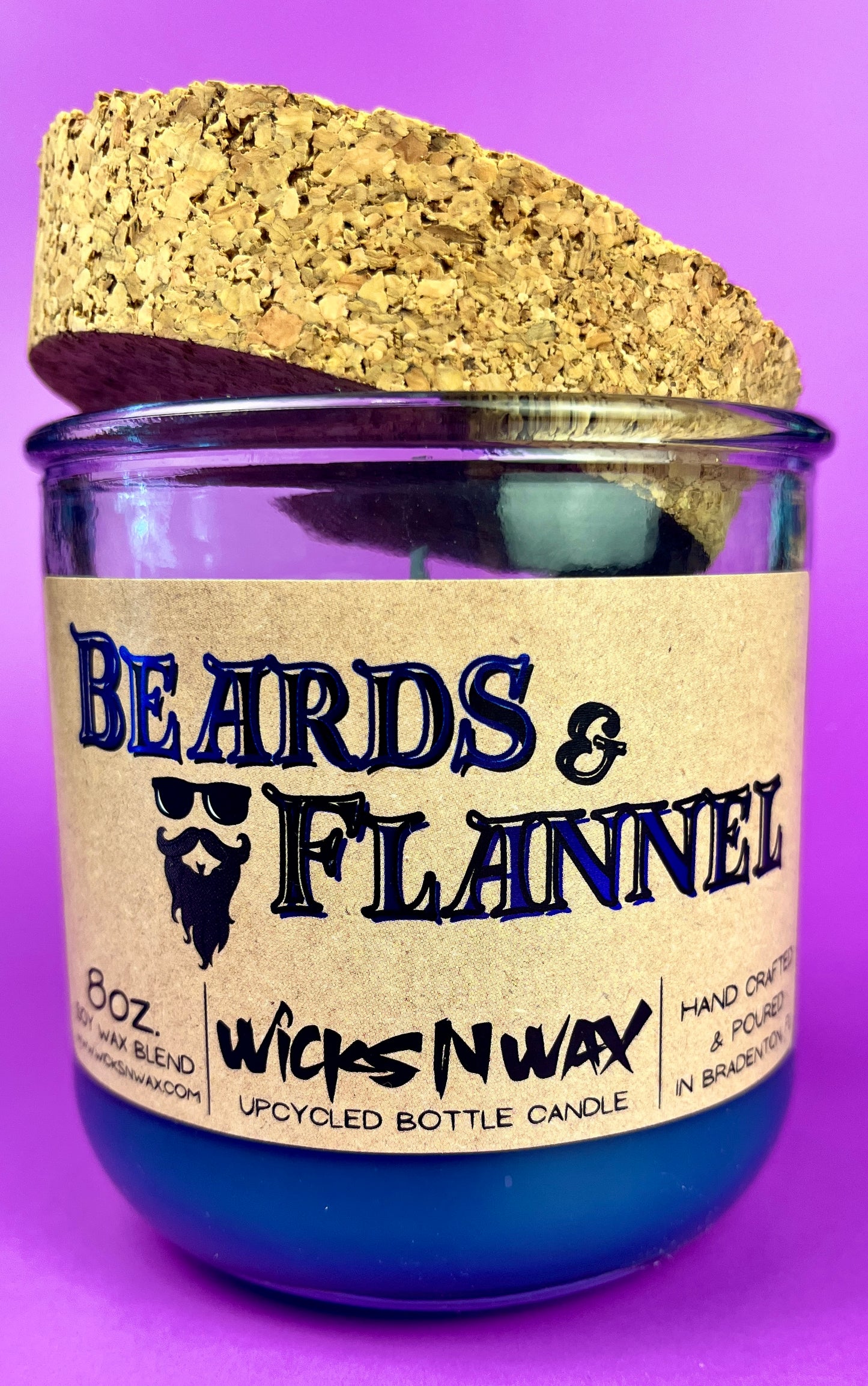 Blue recycled glass candle with cork lid, label text "Beards & Flannel".