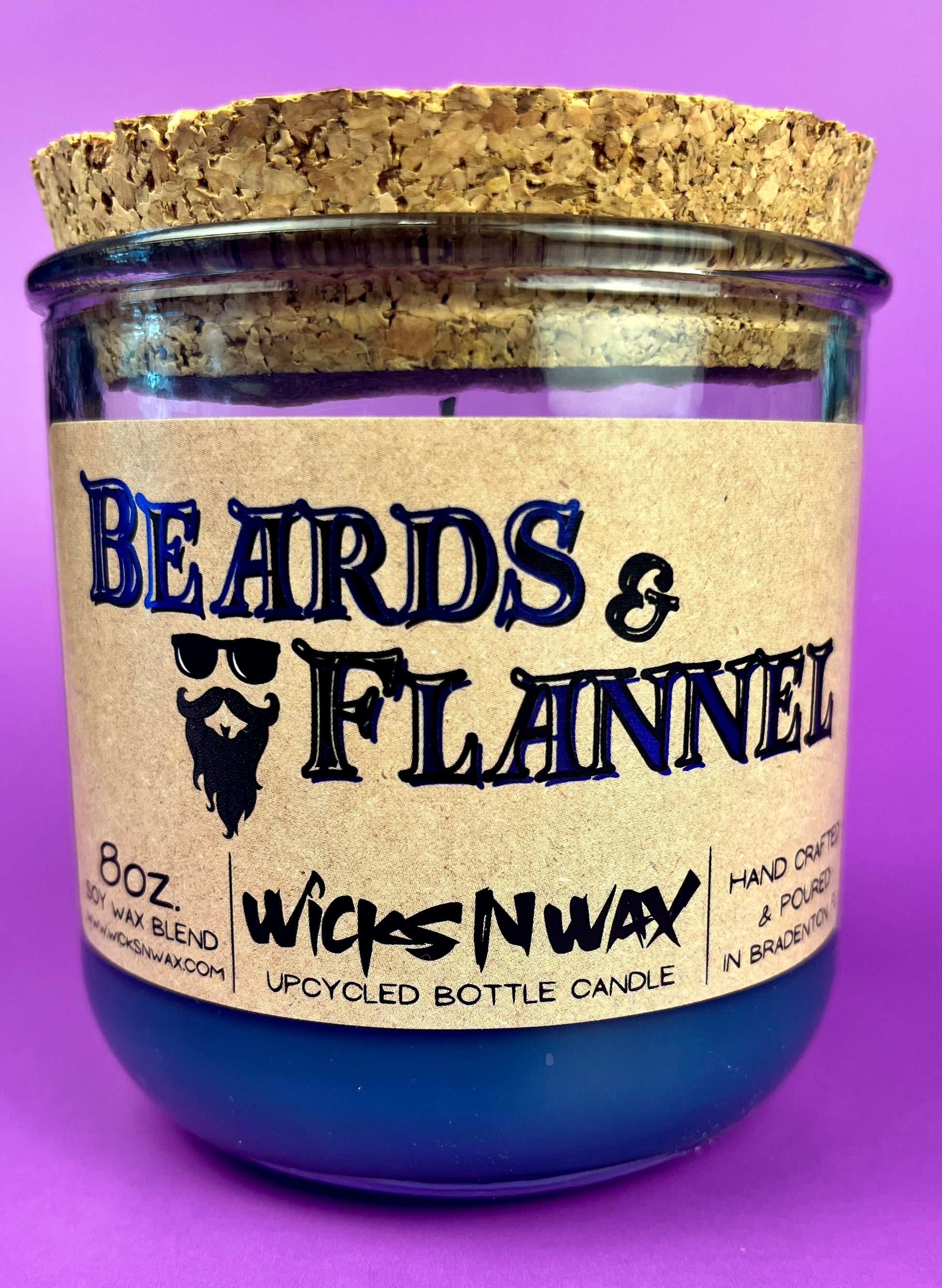 Blue recycled glass candle with cork lid; front label shows "Beards & Flannel".