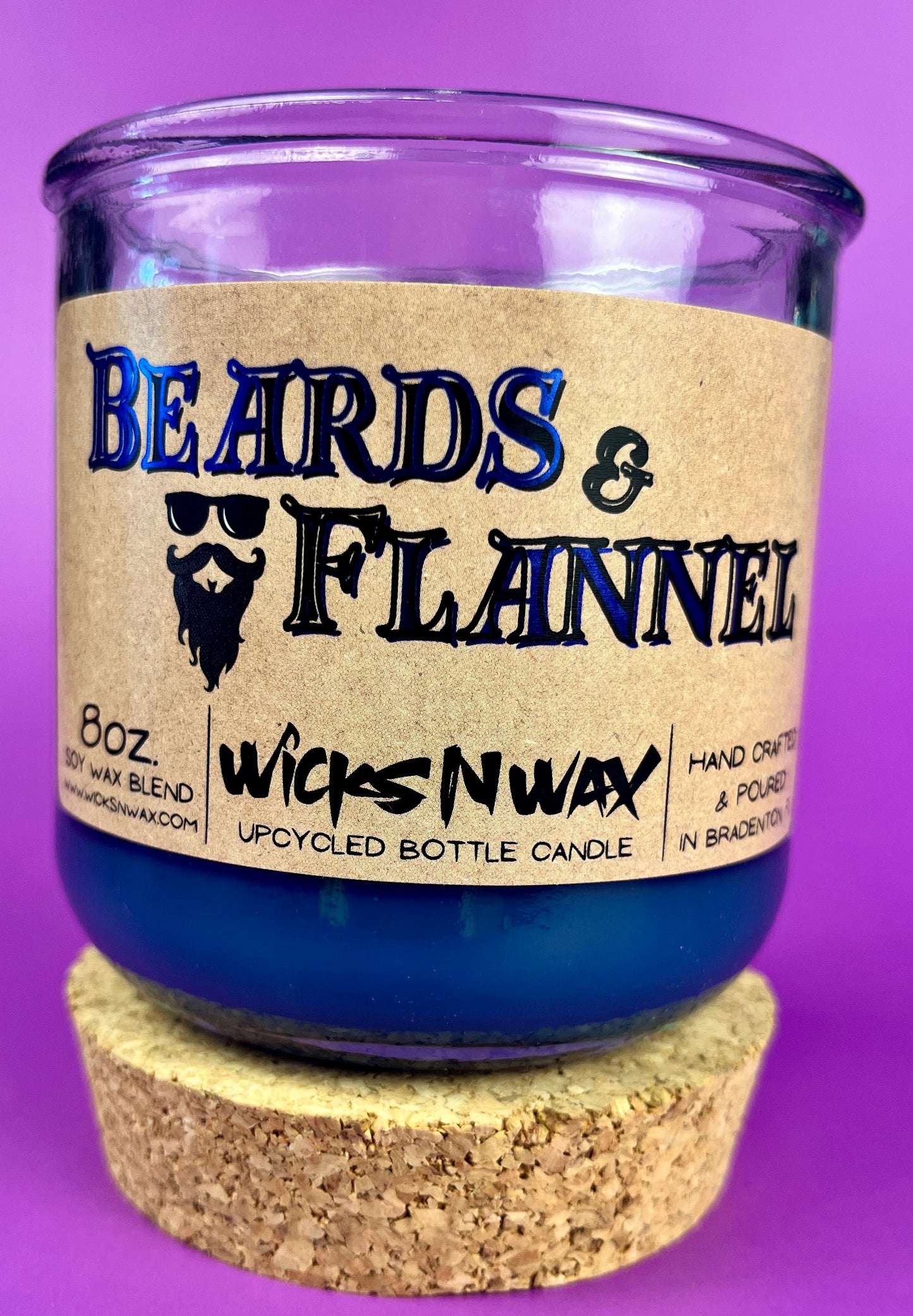 Blue candle with cork base and label "Beards & Flannel" on a glass jar.