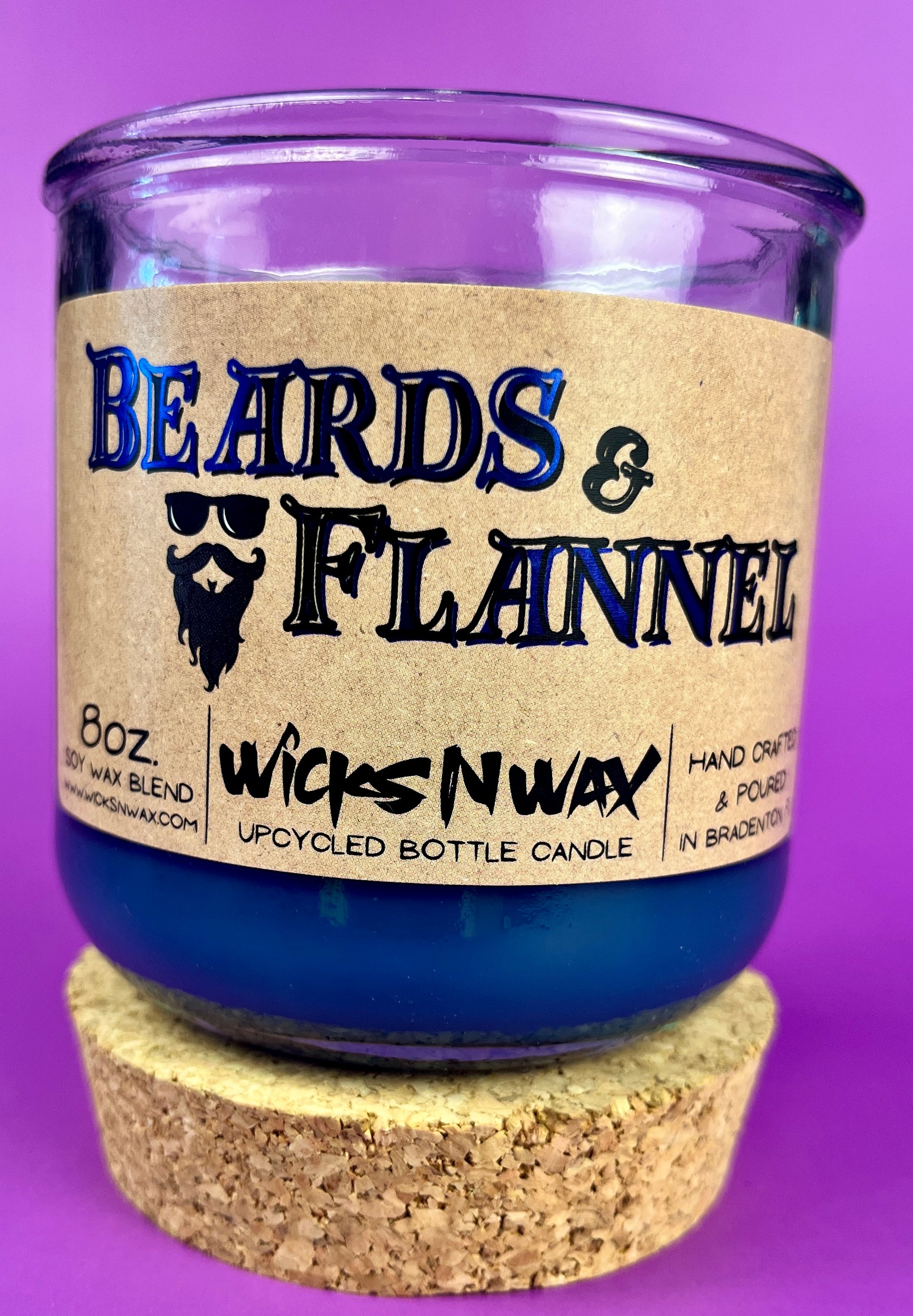 Blue candle with cork base and label "Beards & Flannel" on a glass jar.