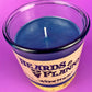 Blue candle in glass jar with wick visible; label reads "Beards & Flannel".