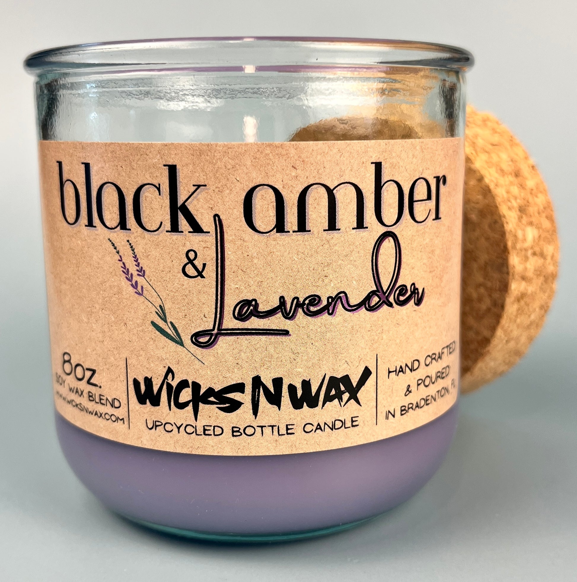 Recycled glass candle jar with purple wax; WicksNWax Black Amber & Lavender label on front
