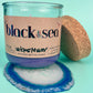 Recycled glass candle in blue glass jar with cork lid and cork base, wax visible