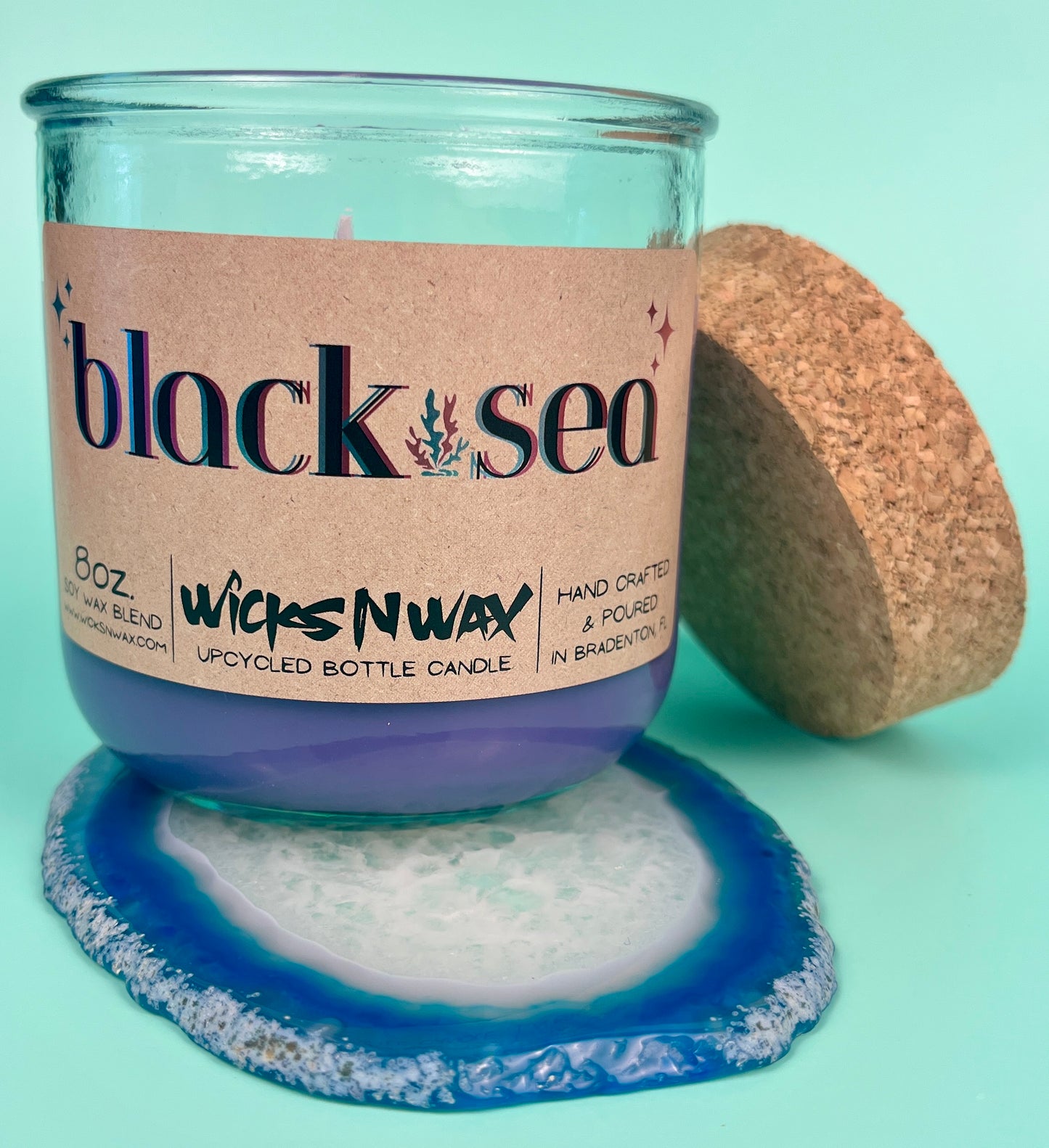 Recycled glass candle in blue glass jar with cork lid and cork base, wax visible
