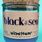 Recycled glass candle in blue jar with cork lid, label and jar front view