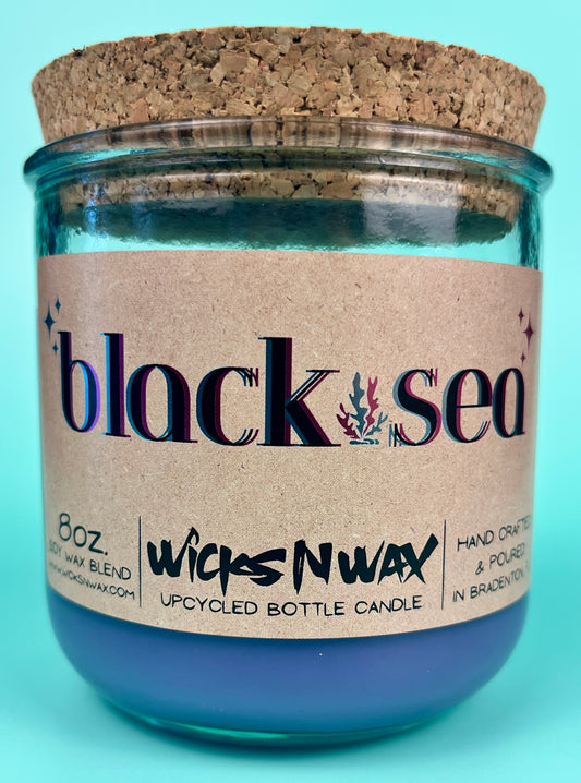 Recycled glass candle in blue jar with cork lid, label and jar front view