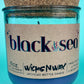 Recycled glass candle in blue jar with cork lid, front label visible