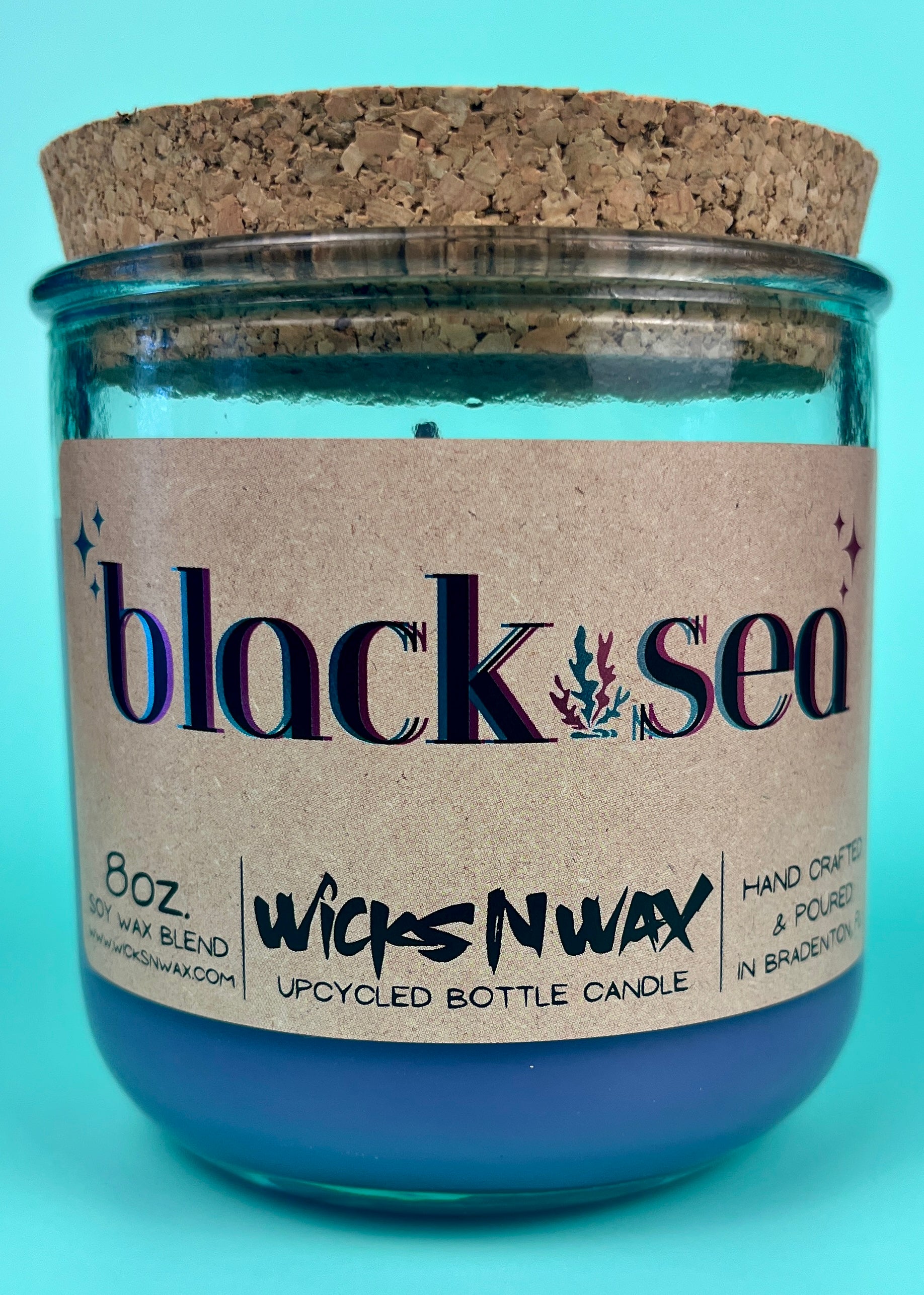 Recycled glass candle in blue jar with cork lid, label and jar opening close-up