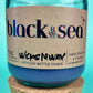 Recycled glass candle in blue glass jar with cork lid, label centered