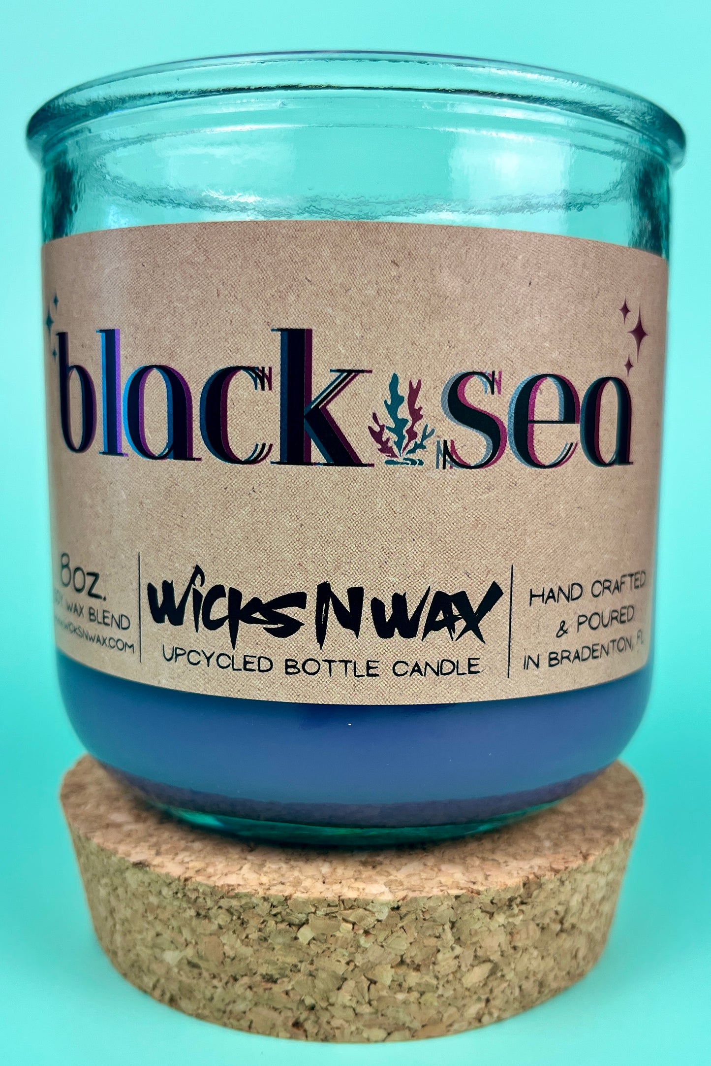 Recycled glass candle in blue glass jar with cork lid, label centered