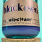 Recycled glass candle in blue jar with cork lid on bottom, front label visible